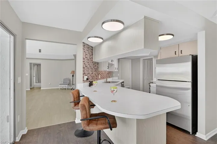 Kitchen with a breakfast bar and modern circular flush-mount LED lighting