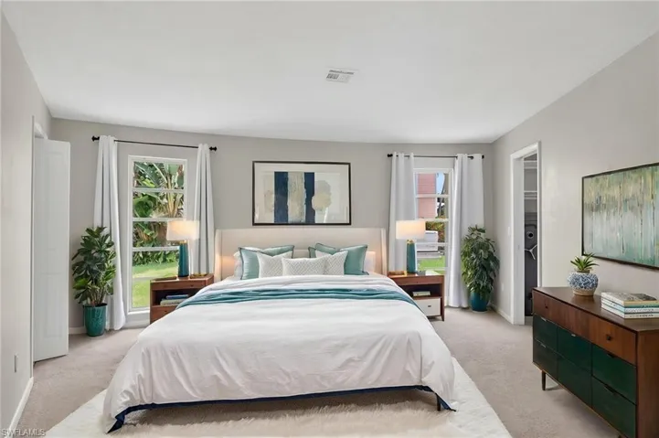 Neutral gray walls complement the carpeted flooring in this King sized bedroom