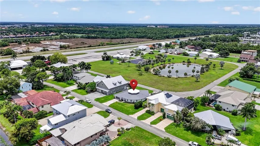 Aerial perspective showcasing a residential area with varied architectural styles, taxiway ad runway.