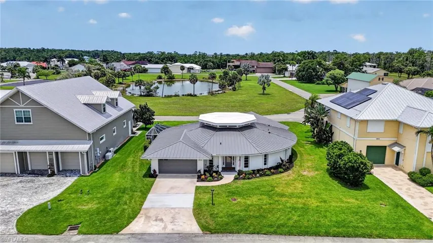 Striking circular residence featuring a metal roof, attached two-car garage, and a concrete driveway