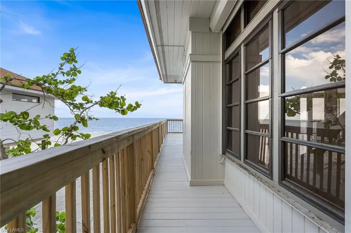 Balcony featuring view of water and beach