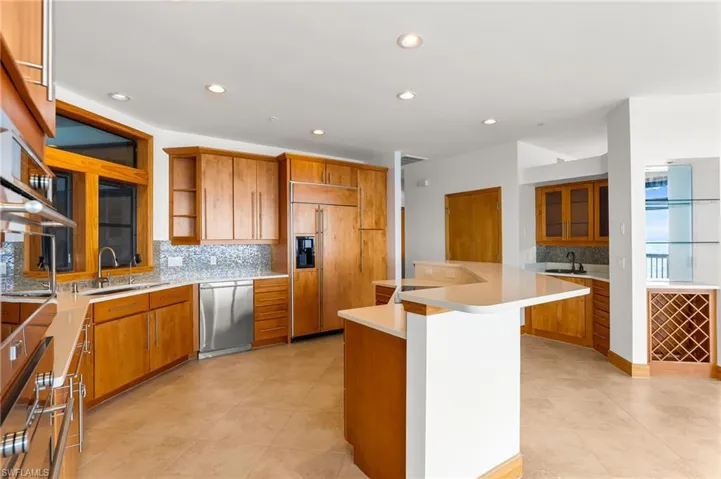 Kitchen featuring backsplash, stainless steel appliances, recessed lighting, open shelves, and wood cabinets