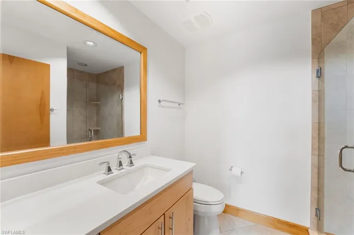 Bathroom featuring vanity, tile patterned floors, and a shower stall