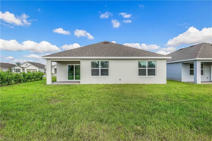 Back of property with a patio and a lawn