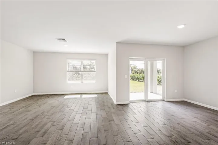 Empty room with a healthy amount of sunlight and wood-type flooring