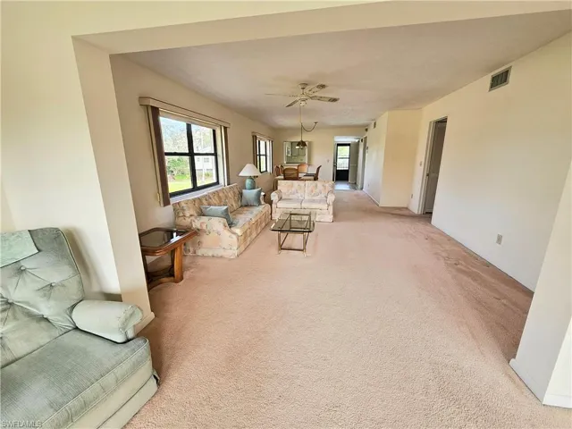 Carpeted living room with ceiling fan