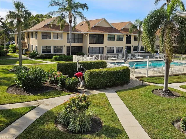 View of home's community featuring a pool and a lawn