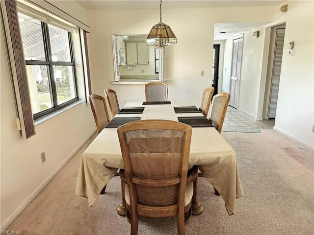 Dining room with light carpet and a chandelier