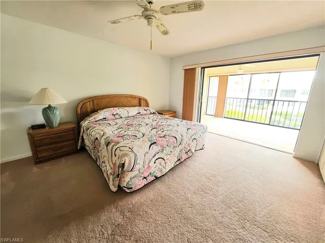 Carpeted bedroom featuring ceiling fan and access to exterior