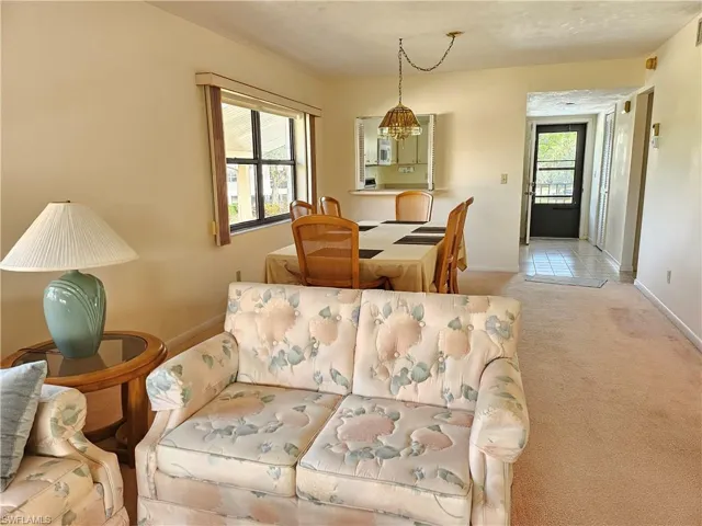 Carpeted living room with a chandelier
