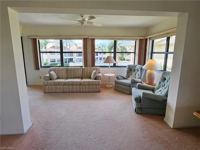 Carpeted living room featuring ceiling fan