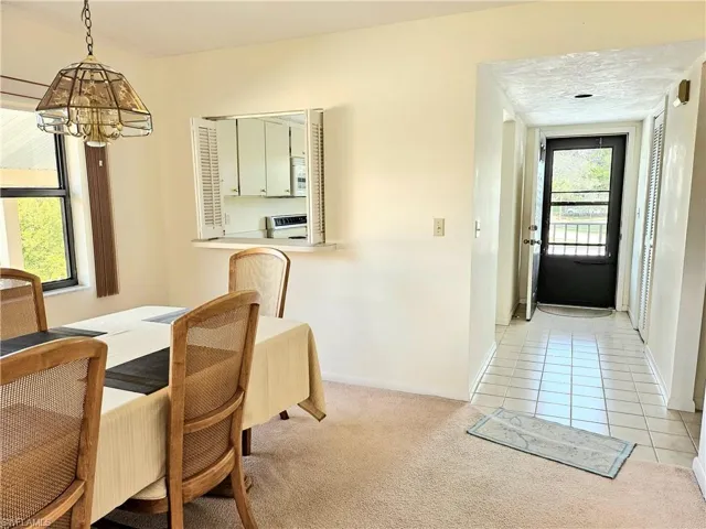 Dining space featuring light carpet and an inviting chandelier