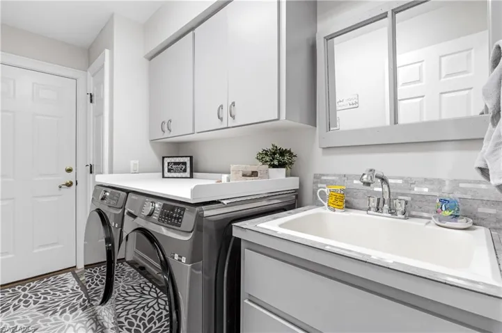 Laundry room has extra storage, large sink and lots of room to fold