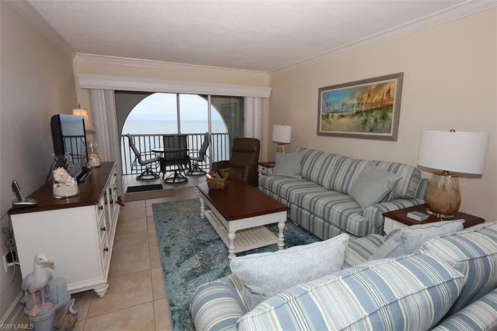 Living area with ornamental molding and light tile patterned floors