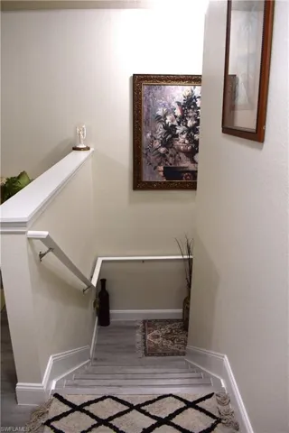 Stairway with baseboards and a textured wall