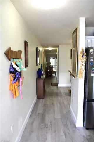 Hall featuring light wood-style flooring and baseboards