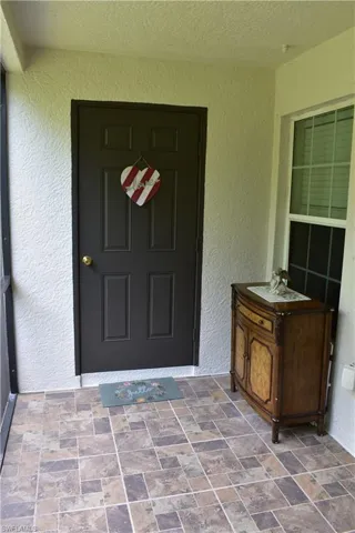 Doorway to property featuring stucco siding
