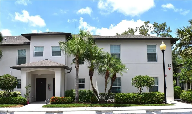 View of front of house with stucco siding and roof with shingles