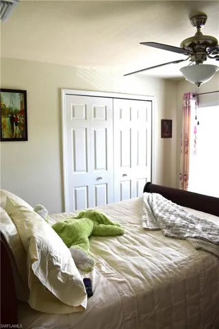 Bedroom featuring a closet, a ceiling fan, and a textured wall