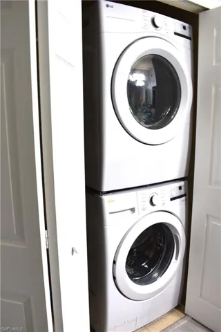 Washroom featuring stacked washer and clothes dryer