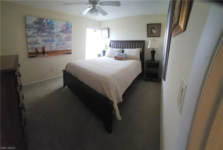 Carpeted bedroom featuring ceiling fan and baseboards