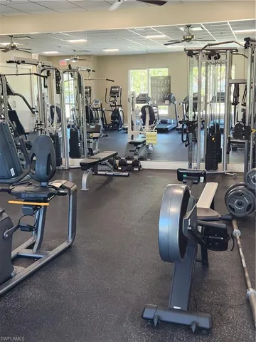 Exercise room featuring ceiling fan and a paneled ceiling