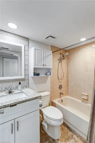 Bathroom featuring recessed lighting, washtub / shower combination, and vanity