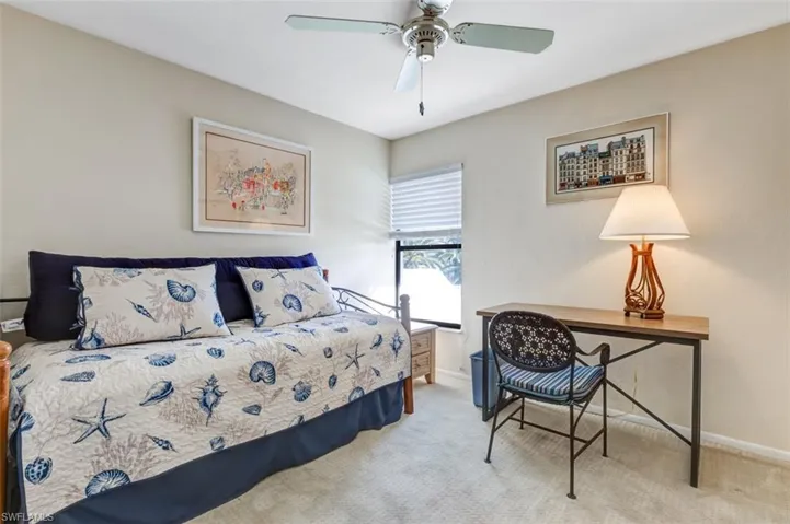 Carpeted bedroom featuring a ceiling fan and baseboards
