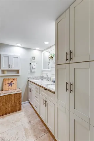 Full bathroom featuring double vanity, light tile patterned floors, and recessed lighting