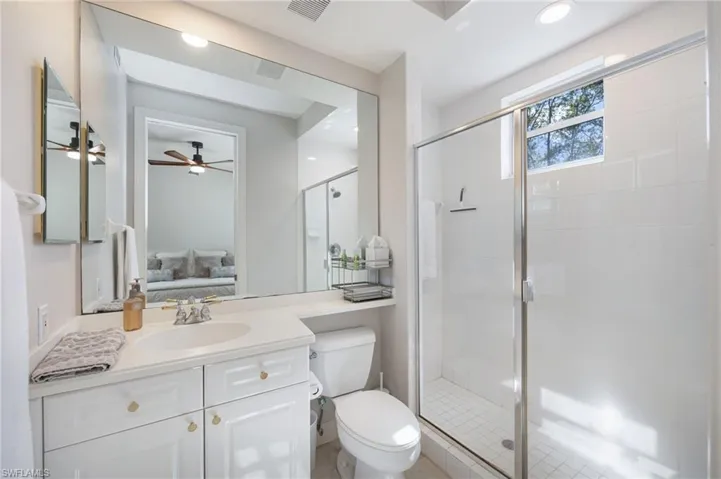 Full bathroom with vanity, a shower stall, ensuite bathroom, recessed lighting, and ceiling fan