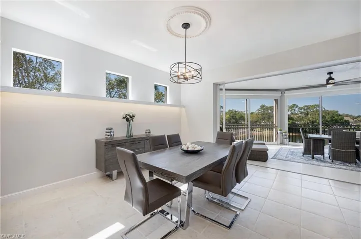 Dining space featuring healthy amount of natural light, light tile patterned flooring, and ceiling fan