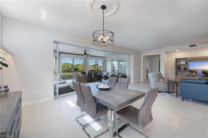Dining space featuring ceiling fan, hanging lights, and light tile patterned flooring