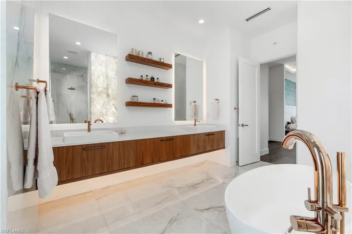 Bathroom with tile patterned floors, double sink vanity, and separate shower and tub