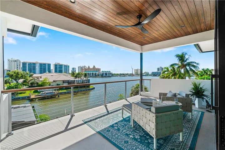 Balcony with ceiling fan, outdoor lounge area, and a water view