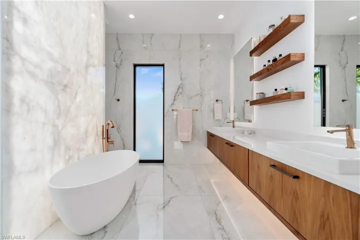 Bathroom with dual vanity, tile patterned floors, and tile walls