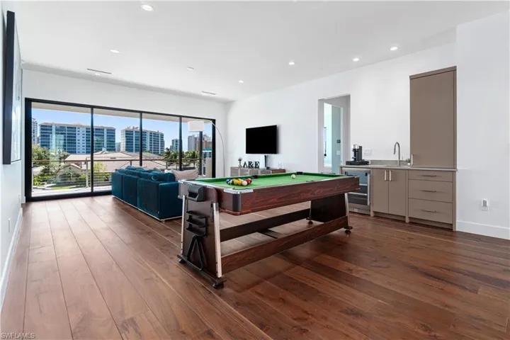 Playroom featuring billiards, dark hardwood / wood-style flooring, sink, and wine cooler