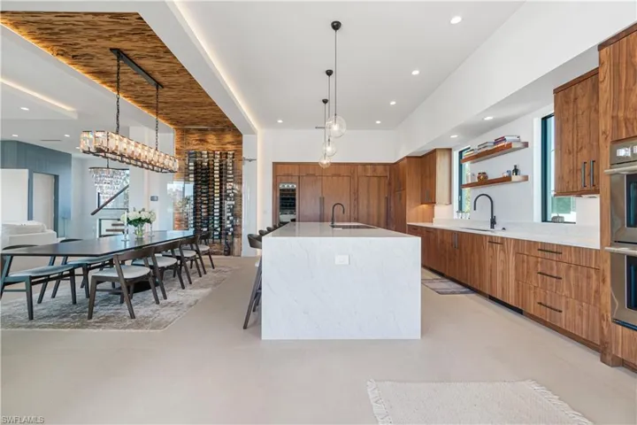 Kitchen featuring a large island, oven, pendant lighting, light tile patterned floors, and sink