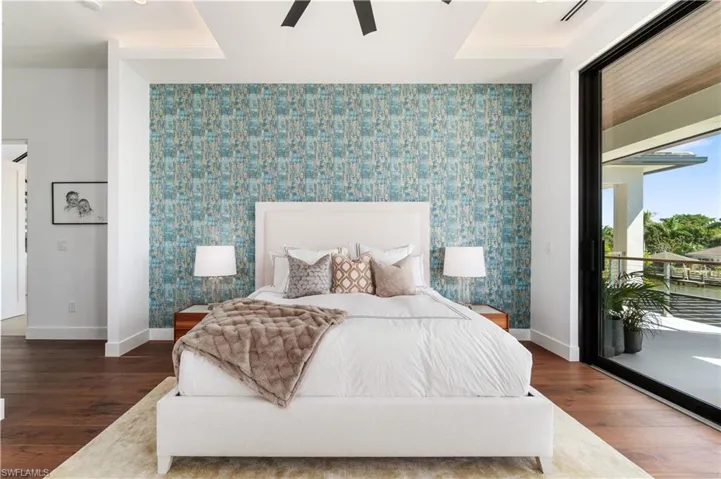 Bedroom with ceiling fan, access to exterior, and dark hardwood / wood-style floors