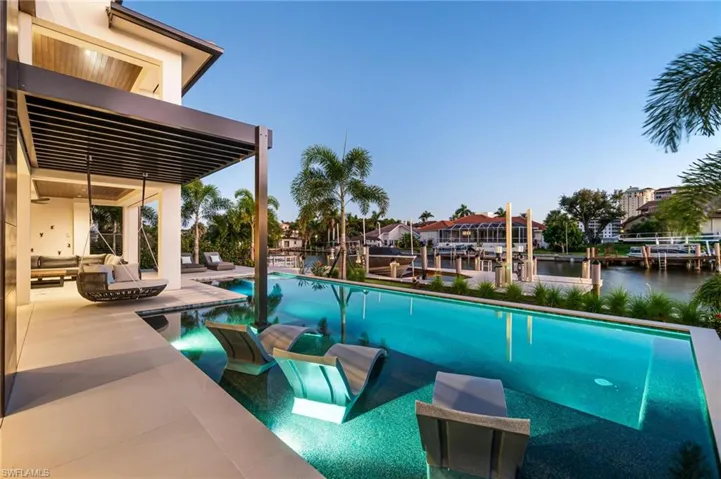 View of swimming pool featuring a water view and a boat dock