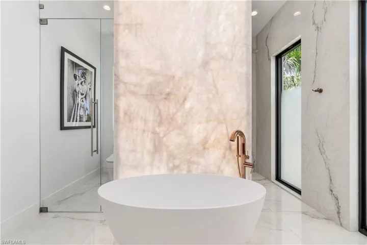 Bathroom featuring toilet, tile patterned floors, and a bathing tub