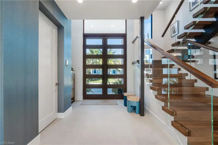 Foyer with elevator access and custom staircase