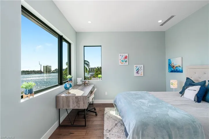 Bedroom featuring dark wood-type flooring and a water view