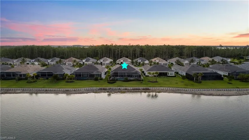 Aerial view at dusk featuring a water view
