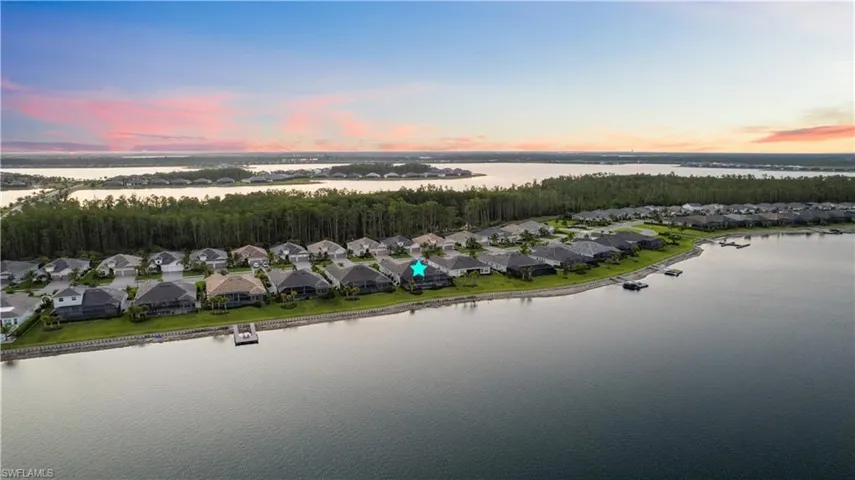 Aerial view at dusk featuring a water view