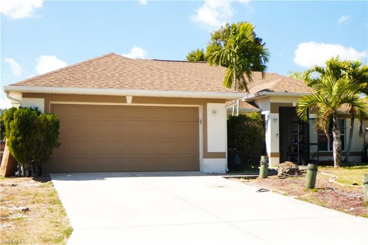 Ranch-style home featuring a garage, a shingled roof, stucco siding, and concrete driveway