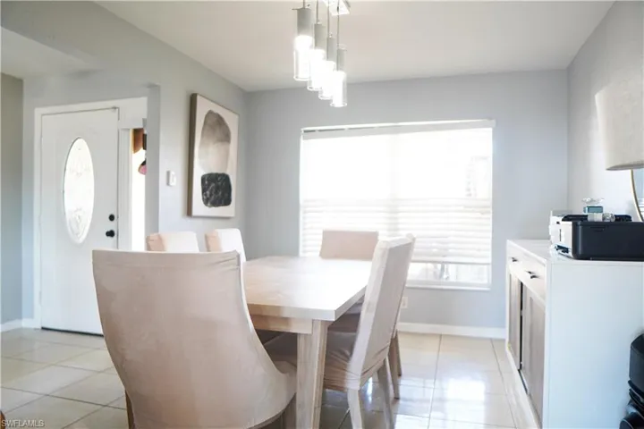 Dining room featuring light tile patterned floors and baseboards