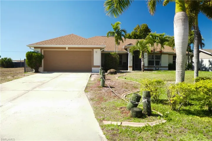 Single story home featuring an attached garage, concrete driveway, stucco siding, roof with shingles, and a front yard