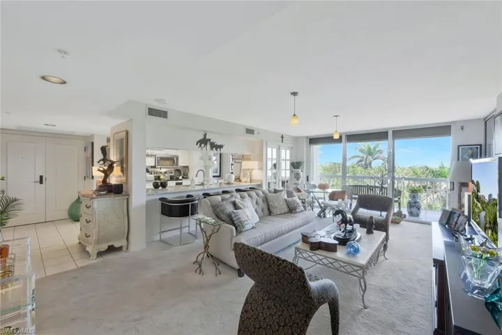 Carpeted living area with expansive windows and tile patterned flooring