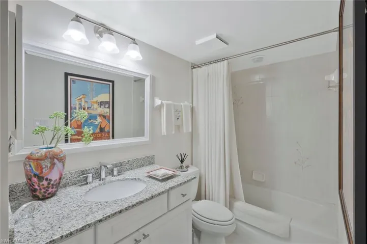 Full bathroom featuring shower / tub combo with curtain and vanity