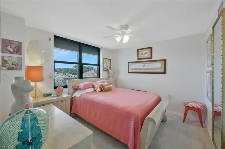 Carpeted bedroom featuring ceiling fan